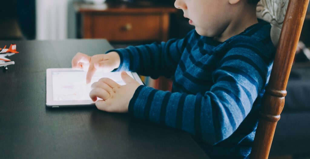 Tablets para Crianças: O Melhor Investimento para Educação e Diversão 17 boy sitting on chair beside table using tablet computer
